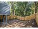 Fenced backyard showing the wood perimeter fence, mature trees, and brick border at 1022 Mariners Ct, Stone Mountain, GA 30083