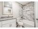 Elegant bathroom featuring a shower-tub combo with marble tiling and granite countertop vanity at 1022 Mariners Ct, Stone Mountain, GA 30083