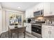 Charming eat-in kitchen with stainless steel appliances, granite counters, and a sliding glass door to the patio at 1022 Mariners Ct, Stone Mountain, GA 30083