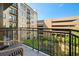 Balcony view showcasing the building's exterior, lush greenery, a small fountain, and outdoor seating at 201 W Ponce De Leon Ave # 402, Decatur, GA 30030