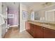 Bathroom featuring double sinks, a granite countertop, rich wooden cabinets, and a separate shower area at 201 W Ponce De Leon Ave # 402, Decatur, GA 30030
