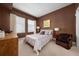 Bedroom featuring brown walls, multiple windows, comfortable seating, and soft lighting for a cozy ambiance at 201 W Ponce De Leon Ave # 402, Decatur, GA 30030