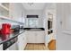 Well-lit kitchen showcasing white cabinets, black countertops, and a stainless steel dishwasher at 300 Peachtree Ne St # 22N, Atlanta, GA 30308