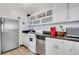 Functional kitchen with stainless steel appliances, white cabinets, and tile floors at 300 Peachtree Ne St # 22N, Atlanta, GA 30308