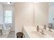 Bathroom features a toilet, sink, mirror, and a window for natural light at 4265 Hurt Bridge Rd, Cumming, GA 30028