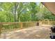 Wooden deck with wooden rails overlooking treelined backyard view and a grill at 4265 Hurt Bridge Rd, Cumming, GA 30028