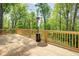 Wooden deck with wooden rails overlooking treelined backyard with an outdoor patio heater at 4265 Hurt Bridge Rd, Cumming, GA 30028
