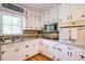 Well-lit kitchen with white cabinetry, granite countertops, stainless steel appliances, and hardwood floors, providing a functional space at 4265 Hurt Bridge Rd, Cumming, GA 30028