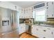 Modern kitchen with stainless steel appliances, white cabinets, and hardwood floors, creating a stylish and functional cooking space at 4265 Hurt Bridge Rd, Cumming, GA 30028