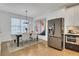 Inviting dining area adjacent to the kitchen features modern art, a stylish table and a stainless refrigerator at 758 Cady Way, Atlanta, GA 30312