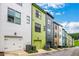 Exterior shot of multi-colored townhomes with garages on a sunny day at 758 Cady Way, Atlanta, GA 30312