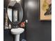 Contemporary powder room with a stylish round mirror and dark gray walls at 758 Cady Way, Atlanta, GA 30312