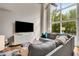 Bright living room with high ceilings, large windows, and comfortable gray sectional sofa at 1356 Peter Haughton Nw Way, Atlanta, GA 30318