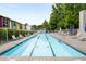 Long, narrow community pool with chairs, umbrellas, and colorful townhomes in the background at 1356 Peter Haughton Nw Way, Atlanta, GA 30318