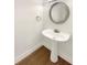Powder room features wood-look flooring, a pedestal sink, and a decorative mirror at 165 N River Dr # B, Atlanta, GA 30350