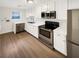 Modern kitchen with stainless steel appliances, white cabinets, and subway tile backsplash at 165 N River Dr # B, Atlanta, GA 30350