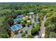 Aerial view of tennis courts and community pool surrounded by lush trees and greenery at 4035 Regal Oaks Dr, Suwanee, GA 30024