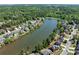 Aerial view showcasing the neighborhood with lush trees surrounding a serene lake community at 4035 Regal Oaks Dr, Suwanee, GA 30024