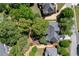 Aerial view of a home with a dark roof nestled among lush trees in a quiet neighborhood at 4035 Regal Oaks Dr, Suwanee, GA 30024