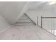 Spacious carpeted attic with built-in shelving and natural light from the window at 4035 Regal Oaks Dr, Suwanee, GA 30024