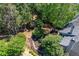 Aerial view of a landscaped backyard garden with stone pathway, surrounded by mature trees at 4035 Regal Oaks Dr, Suwanee, GA 30024