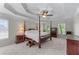 Spacious bedroom featuring a tray ceiling, ceiling fan, carpet, and a four-poster bed at 4035 Regal Oaks Dr, Suwanee, GA 30024