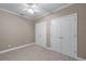Carpeted bedroom with two closets, ceiling fan, and neutral color at 4035 Regal Oaks Dr, Suwanee, GA 30024