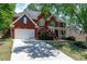 Well-maintained home with a long driveway and a lovely red brick facade at 4035 Regal Oaks Dr, Suwanee, GA 30024