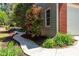 Home exterior featuring a sidewalk lined with garden beds and flowering plants leading to the entrance at 4035 Regal Oaks Dr, Suwanee, GA 30024