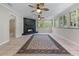 Living room features a fireplace, tile flooring, ceiling fans, multiple windows, and a decorative rug at 4035 Regal Oaks Dr, Suwanee, GA 30024