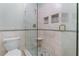Modern shower featuring custom tile work, a glass door, and built-in shelving at 4035 Regal Oaks Dr, Suwanee, GA 30024
