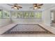 Sunroom featuring tile flooring, multiple windows, ceiling fans, and a decorative rug at 4035 Regal Oaks Dr, Suwanee, GA 30024