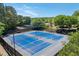 Well-maintained blue tennis courts surrounded by trees with shade structures in background at 4035 Regal Oaks Dr, Suwanee, GA 30024