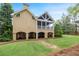Rear view of the home showing a covered porch with pillars overlooking the well-kept lawn at 454 Langley Oaks Dr, Marietta, GA 30067