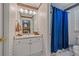 A bathroom featuring a vanity, a sink with a mirror, and a shower-tub combo with a blue curtain at 454 Langley Oaks Dr, Marietta, GA 30067