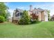 Expansive backyard view showcasing the home's screened porch, mature trees, and well-maintained lawn at 454 Langley Oaks Dr, Marietta, GA 30067