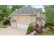 Side exterior view of a beautiful home with a three car garage and manicured landscaping at 454 Langley Oaks Dr, Marietta, GA 30067