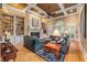 Spacious living room with coffered ceilings, fireplace, built-in shelving, and plush leather furniture at 454 Langley Oaks Dr, Marietta, GA 30067