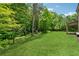 Large backyard with expansive green lawn and trees next to the home at 4702 Jellico Dr, Powder Springs, GA 30127