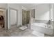 Bright bathroom featuring a soaking tub, shower, and tile flooring at 4702 Jellico Dr, Powder Springs, GA 30127