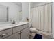 Bathroom featuring a toilet, tub, shower, and a sink with a white marble countertop at 4702 Jellico Dr, Powder Springs, GA 30127