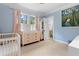 Bright Bedroom featuring a baby crib, dresser, and adjacent bathroom at 557 E Wesley Ne Rd, Atlanta, GA 30305