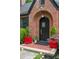 Close-up of the Tudor-style arched front entrance features brickwork, and bright red planters at 557 E Wesley Ne Rd, Atlanta, GA 30305