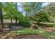Secluded backyard retreat with wooden deck surrounded by lush greenery and mature trees at 6725 Polo Dr, Cumming, GA 30040