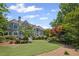 Beautiful home exterior with a manicured lawn, mature trees, and architectural details at 6725 Polo Dr, Cumming, GA 30040