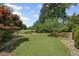 Beautiful backyard with lush green lawn, mature trees, and stone pathways creating a serene outdoor oasis at 6725 Polo Dr, Cumming, GA 30040