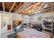 Partially finished basement with exposed beams, shelves, and storage solutions, with an adjacent finished living space at 6725 Polo Dr, Cumming, GA 30040