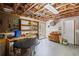Unfinished basement area featuring exposed wooden beams, a workbench, and ample storage space at 6725 Polo Dr, Cumming, GA 30040