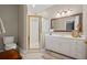 Bathroom featuring a gold-trimmed glass shower, white cabinets, and an ornate mirror at 6725 Polo Dr, Cumming, GA 30040