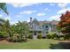 Stunning backyard showcasing the home's architecture with a large lawn and mature landscaping at 6725 Polo Dr, Cumming, GA 30040